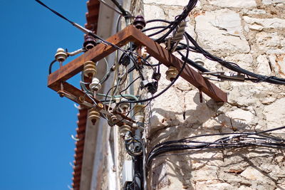 Bunchl of electrical wires attached to a stone wall of the traditional house in dalmatia, croatia