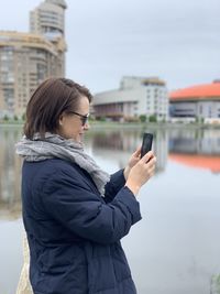 Woman using mobile phone in city