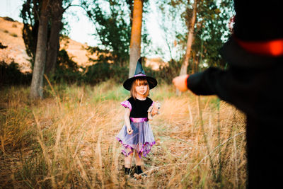 Girl with brother wearing costume during halloween at forest