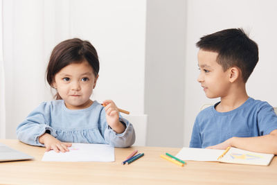 Boy drawing on book at home