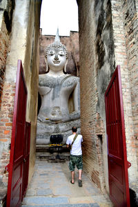 Rear view of man statue outside building