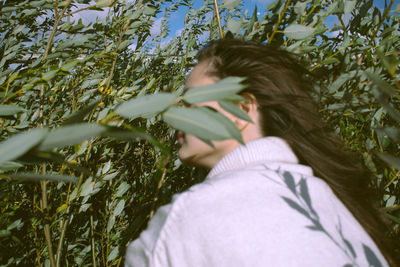 Portrait of young woman lying on plant