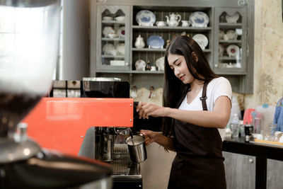 Woman holding a while standing in cafe