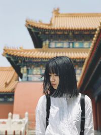 Rear view of woman standing outside temple