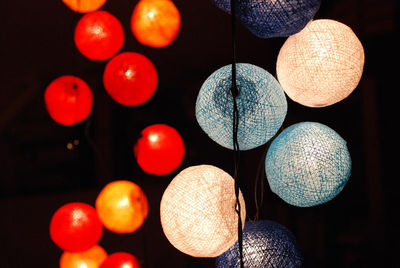 Close-up of illuminated lanterns over black background