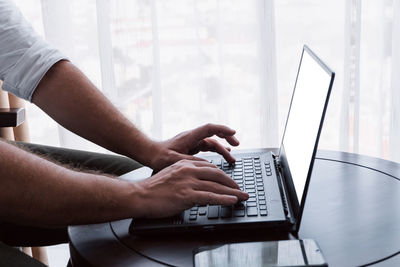 Midsection of man using laptop at office