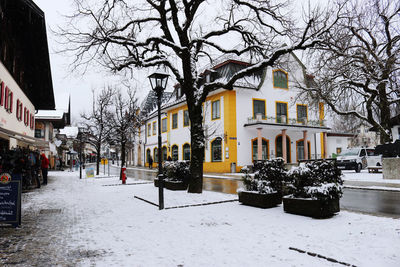 Snow covered street amidst buildings in city