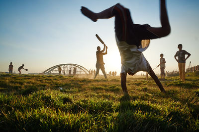 Boy performing stunt on grassy field