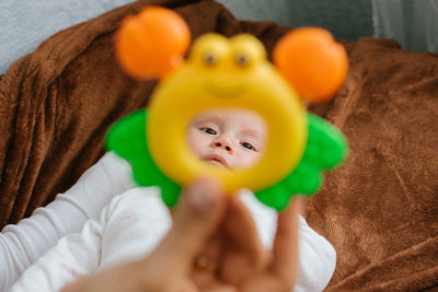 First rattle toy for baby. rattles and teethers, teething toys. cute newborn baby girl looking at