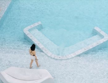 High angle view of woman standing by swimming pool