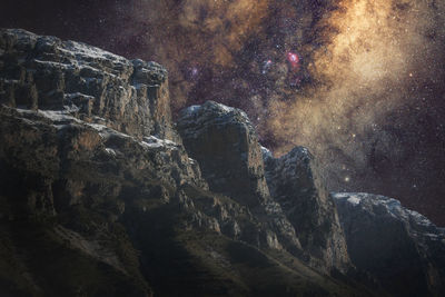 Low angle view of rock formation against sky at night