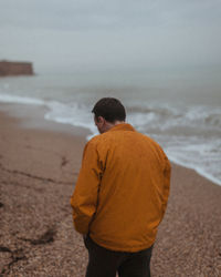 Rear view of man standing at beach