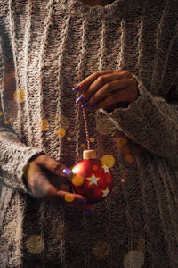 Midsection of woman holding christmas decoration