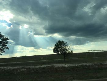 Scenic view of field against cloudy sky