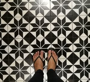 Low section of woman standing on tiled floor