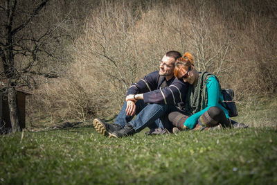 Full length portrait of a young man sitting on grass