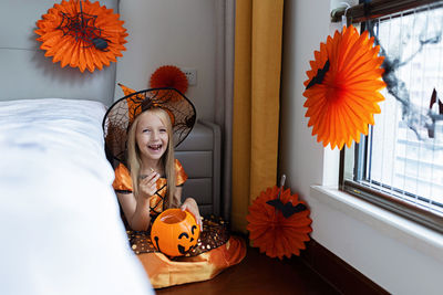 Portrait of smiling girl sitting at home during halloween