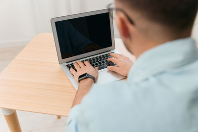 Midsection of woman using laptop on table