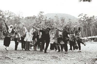 People on grassy field against sky