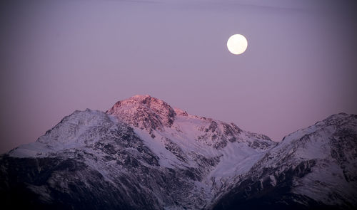 Scenic view of snowcapped mountains against sky at night