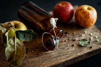 Bottle decorated with fruit on old wooden plate