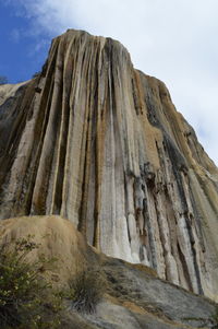 Low angle view of rock formation on land against sky