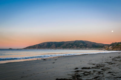 Scenic view of beach against sky during sunset