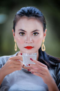 Portrait of smiling young woman blowing bubbles