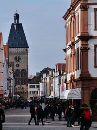 People walking on street against buildings in city