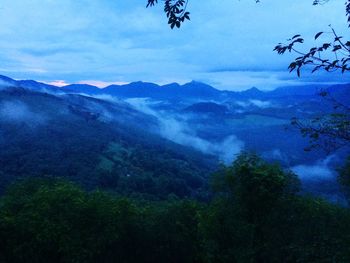 Scenic view of mountains against cloudy sky