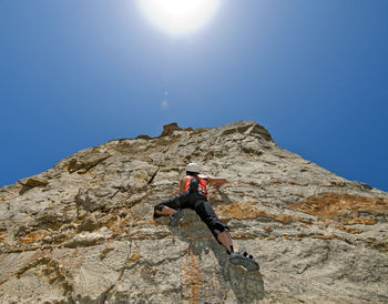 Woman climbing limestone rock face in swanage / uk