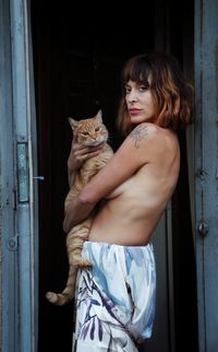 Young woman with her cat looking at camera