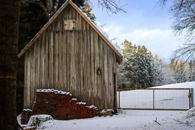 Built structure on snow covered field against sky