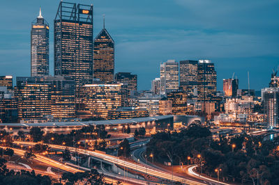 Aerial view of illuminated buildings in city against sky