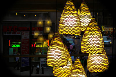 Close-up of illuminated lighting equipment hanging at night