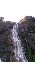 Scenic view of waterfall against sky