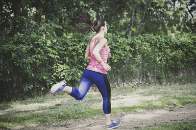 Full length of young woman running at park