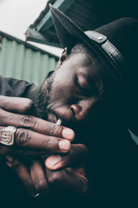 Close-up portrait of man making face against black background