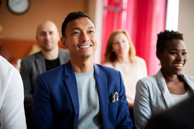 Smiling entrepreneurs sitting in office meeting at workplace