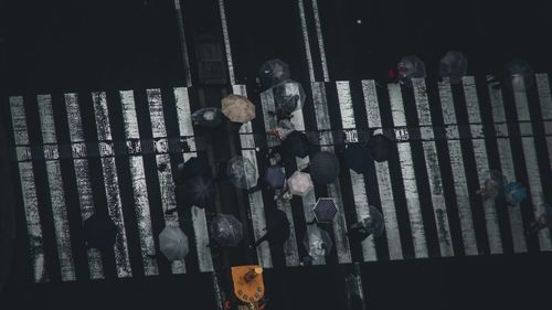 People standing on metal fence at night