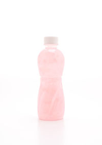 Close-up of pink bottle against white background