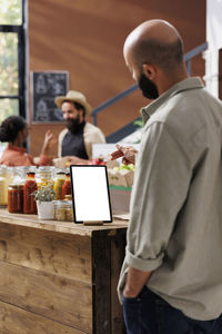 Rear view of man working at table