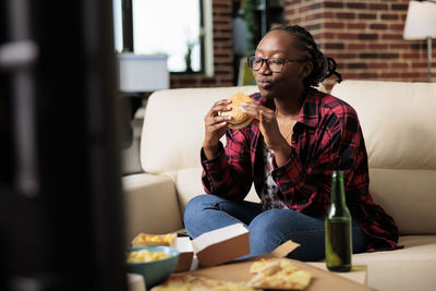 Woman eating burger at home