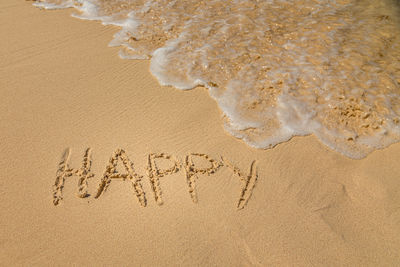 High angle view of text on sand at beach