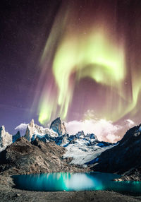 Scenic view of snowcapped mountains against sky at night