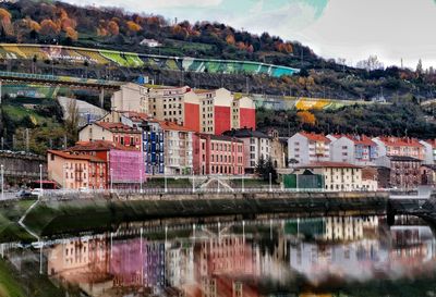 River by buildings in city against sky