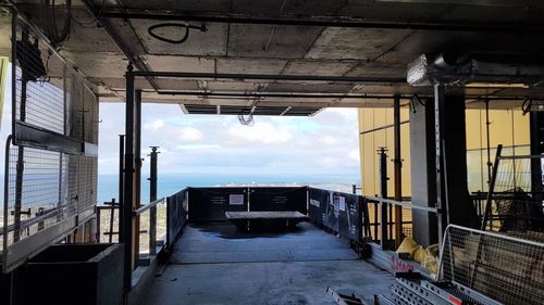 Corridor of building by sea against sky