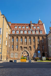 Road by building against clear blue sky