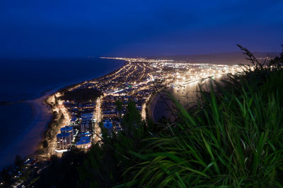 Aerial view of illuminated sea against sky at night