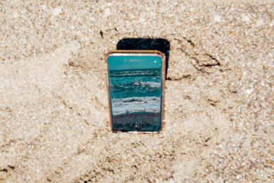 Directly above view of smart phone at beach
